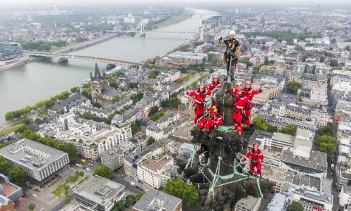 Was für ein beeindruckendes Bild: Das Höhenrettungsteam der Feuerwehr posiert entspannt aber abgesichert am höchsten Punkt des Doms. Foto: Feuerwehr Köln