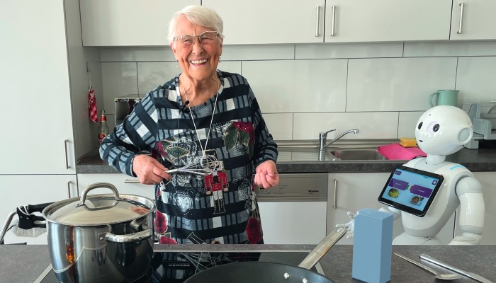 Roboter „Pepper“ unterstützt Wilma Keulertz beim Kochen mit Rezepten. Foto: Diakonie Michaelshoven